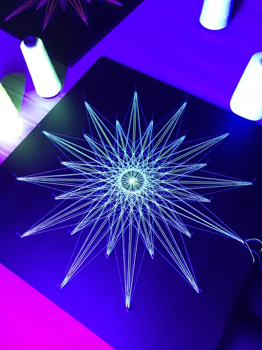 String art with neon string under blacklight