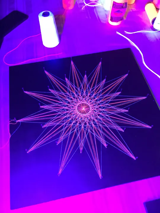 String art with neon string under blacklight