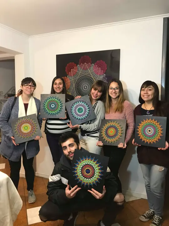 Group from a Fractalería string art workshop with their pieces