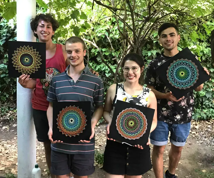 Group from a Fractalería string art workshop with their pieces