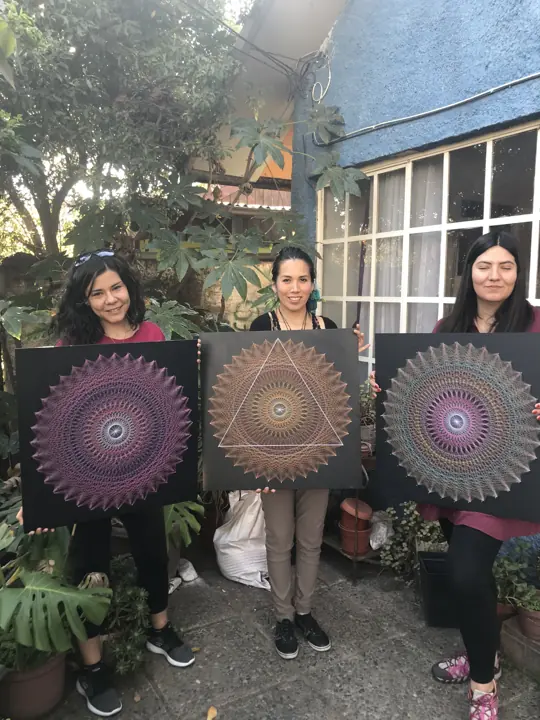 Group from a Fractalería string art workshop with their pieces
