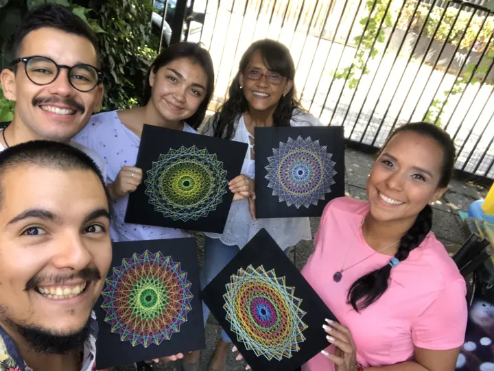 Group from a Fractalería string art workshop with their pieces